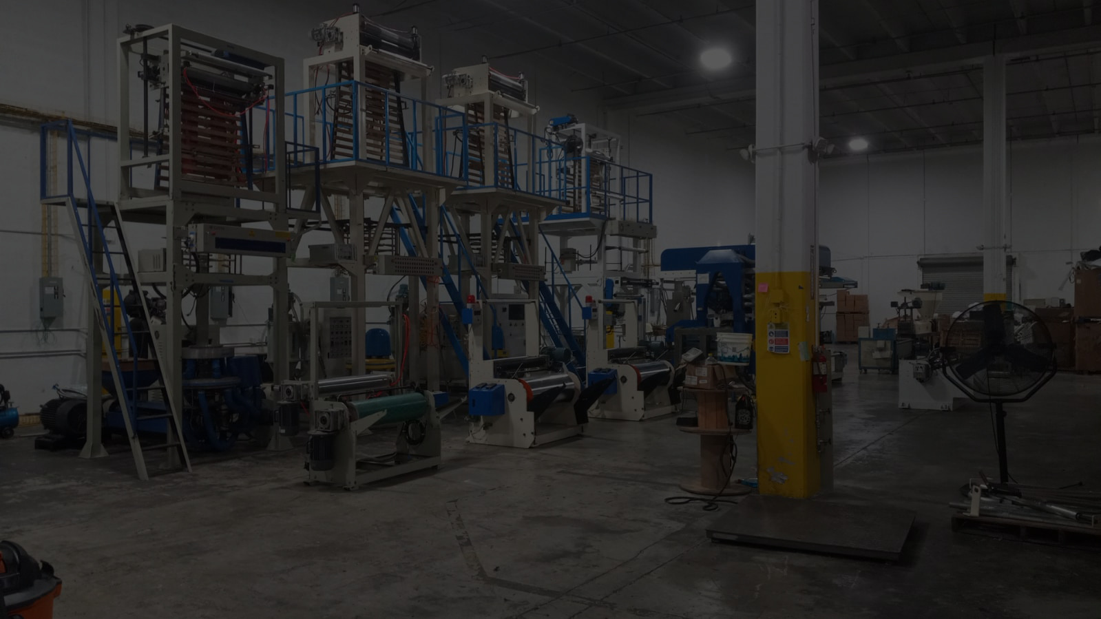 Industrial plastic bag manufacturing machines inside production facility
